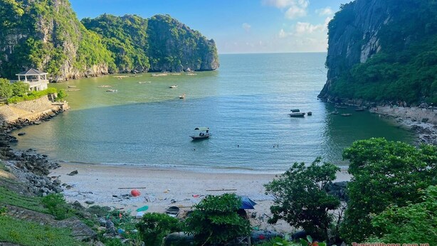 A coastal view with a beach, boats, and a pavilion.