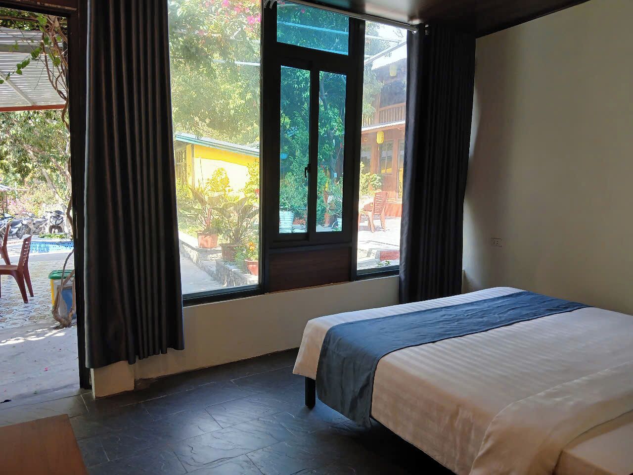 A bedroom with a bed, a window, and a view of the outside.
