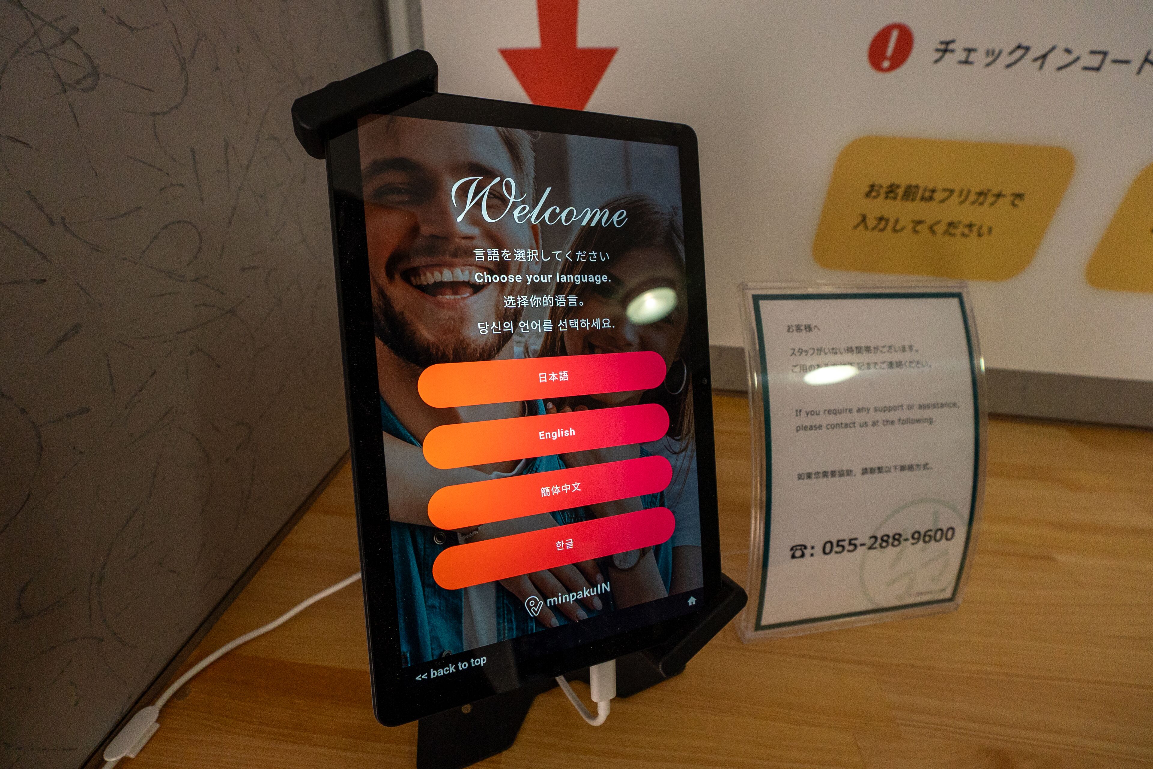 A digital kiosk with a welcome screen and language selection options.