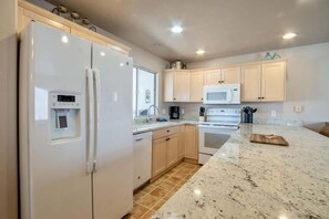 A kitchen with a refrigerator, microwave, oven, and granite countertop. - Las Palmas Resort #1210 | All-Inclusive Amenities (Saint George)