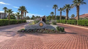 A sign for Cas Palmas Resort & Condominiums with a paved entrance and palm trees. - Las Palmas Resort #1214 | All-Inclusive Amenities (Saint George)