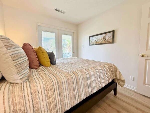 A bedroom with a bed, pillows, a window, and a door. - Las Palmas Resort #1633 | All-Inclusive Amenities (Saint George)