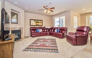 A living room with a sectional sofa, a recliner, a fireplace, and a ceiling fan. - Las Palmas Resort #1702 | All-Inclusive Amenities (Saint George)