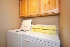 A laundry area with a washing machine and a cabinet above it. - Las Palmas Resort #1907 | All-Inclusive Amenities (Saint George)