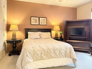 A bedroom with a large bed, two bedside lamps, a flat-screen TV, and two framed pictures on the wall. - Las Palmas Resort #1907 | All-Inclusive Amenities (Saint George)