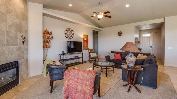 A living room with a fireplace, a television, a sofa, and a coffee table.
