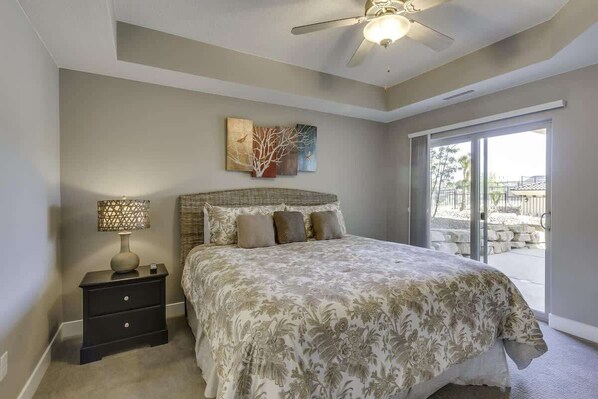 A bedroom with a bed, a nightstand, a lamp, and a ceiling fan.