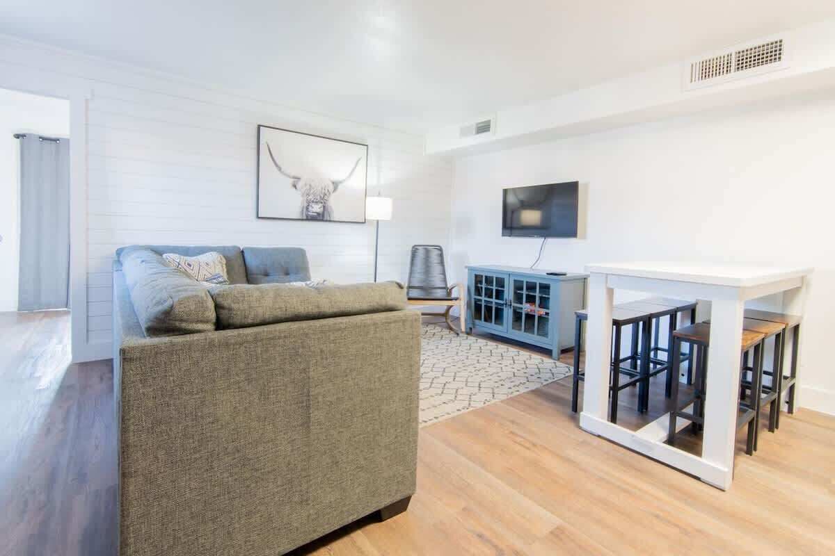 A modern living room with a sofa, a TV, a cabinet, and a table.