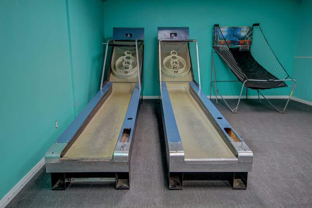 Dos camas bronceadoras en una habitación con paredes verde azulado y piso alfombrado.