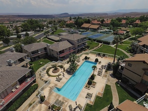 Zona residencial con piscina, varios edificios y vista a montañas distantes.