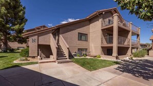 A multi-story building with a central staircase, balconies, and a clear sky.