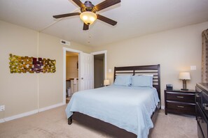 A bedroom with a bed, nightstands, a dresser, a ceiling fan, and a wall art piece. - Sports Village Resort | All Amenities Included | R2 (Saint George)