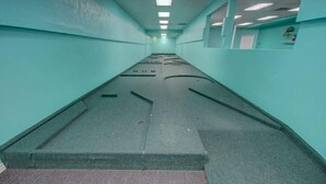 A corridor with a carpeted floor and walls painted in a teal color.