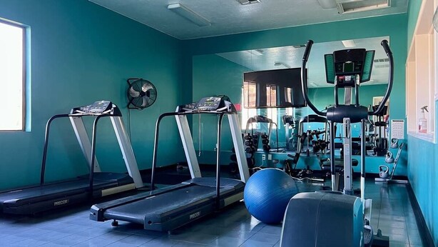 A gym with treadmills, exercise balls, and weight machines.
