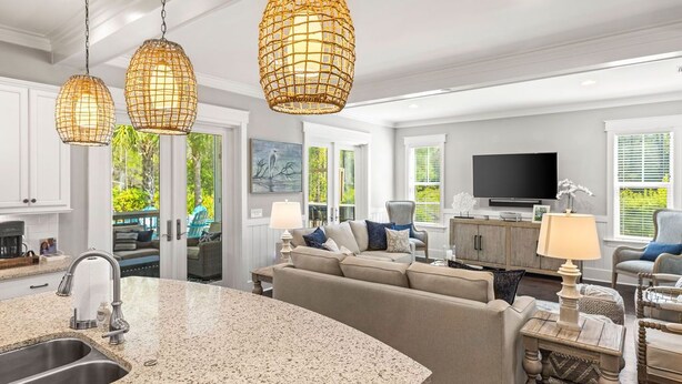 A modern kitchen with granite countertops, a built-in sink, and pendant lighting. - Coastal Elegance at NatureWalk: Modern Retreat Minutes from the beach! (Santa Rosa Beach)