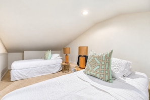 A bedroom with two beds, a nightstand, lamps, and a ceiling light. - Blue Tide 6B - Beachfront 3BR/3BA Seagrove Beach Condo - Sleeps 8 - Beach Setup Included (Inlet Beach)