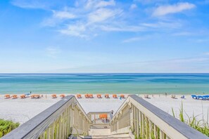 A wooden staircase leading to a beach with rows of orange and blue beach umbrellas. - Blue Tide 6B - Beachfront 3BR/3BA Seagrove Beach Condo - Sleeps 8 - Beach Setup Included (Inlet Beach)
