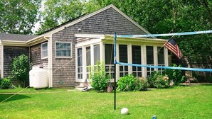Um quintal com uma rede de voleibol, um reservatório de água branco e bandeiras americanas.