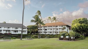 Ein Hotel mit mehreren Etagen, Außenbereich und Palmen.