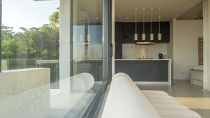 Una cocina moderna con encimeras oscuras, una isla central e iluminación colgante.