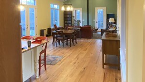 Un espace de vie à aire ouverte comprenant une table à manger, des chaises, un canapé et une bibliothèque.