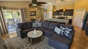 A modern living room with a sectional sofa, a round coffee table, and a patterned rug.