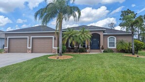 A two-story house with a garage, a front porch, and a well-maintained lawn.