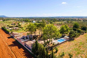 Vista aérea de um bairro residencial com casas, piscina e vegetação ao redor.