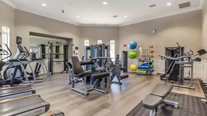 Un gimnasio con cintas de correr, máquinas de pesas y pelotas de ejercicio.