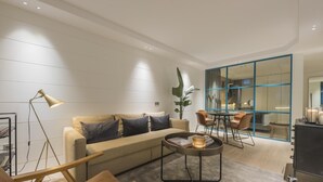 Una sala moderna con sofá, mesa de centro y comedor con sillas y mesa.