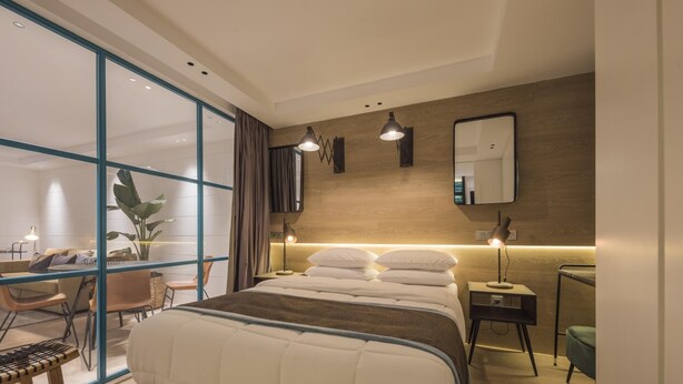 Una habitación de hotel moderna con una cama grande, un escritorio y una silla.