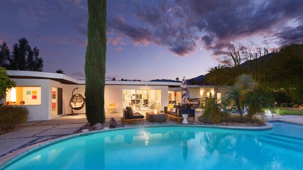 Une maison moderne dotée d’une piscine, d’un espace extérieur aménagé et d’un intérieur bien éclairé.