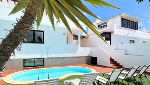 A modern house with a swimming pool, white lounge chairs, and a staircase leading to an upper level. - Laguna Home by Best Holidays Fuerteventura (Corralejo)