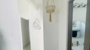 A hallway with a hanging light fixture and a wall decoration that reads "Hello there". - Casa LindaMaria 4 mins from the airport 6 mins from isla verde (Carolina)
