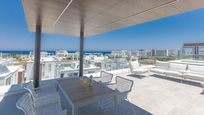 A rooftop terrace with a table, chairs, and a view of the sea and cityscape. - Protaras Olivine Villa OL9 - Beautiful 4BDR Protaras Villa with Private Pool (Protaras)