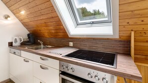 Une cuisine moderne dotée d’une verrière, d’un four encastré et d’appareils électroménagers en acier inoxydable.
