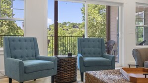 A balcony with two blue armchairs, a wicker side table, and a woven ottoman. - Lakefront Retreat on Lake Taneycomo, Near Branson Landing and Attractions (Branson)