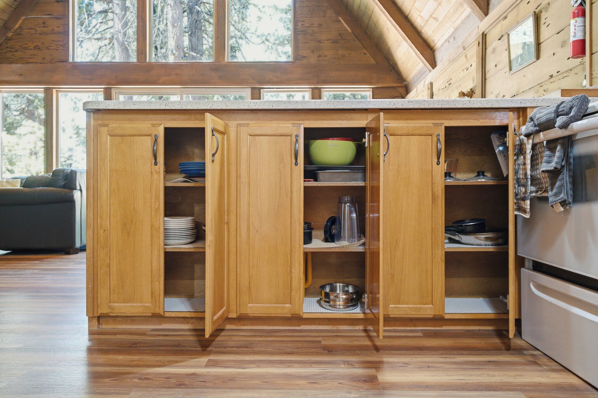 Una cocina de madera con armarios abiertos, una estufa y vistas al exterior.