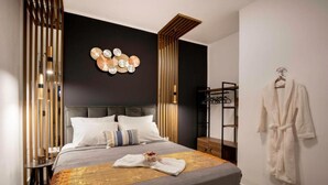 Une chambre d’hôtel moderne avec un grand lit, une tête de lit en bois, un luminaire fixé au mur et un peignoir suspendu à un porte-vêtements.