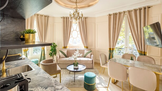 A modern living room with a sofa, coffee table, and dining area. - Merveil - Luxury Suite - Louvre - Ours I (Paris)