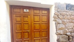 A wooden double door with a sign above it.