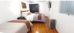 1 dormitorio y tabla de planchar con plancha