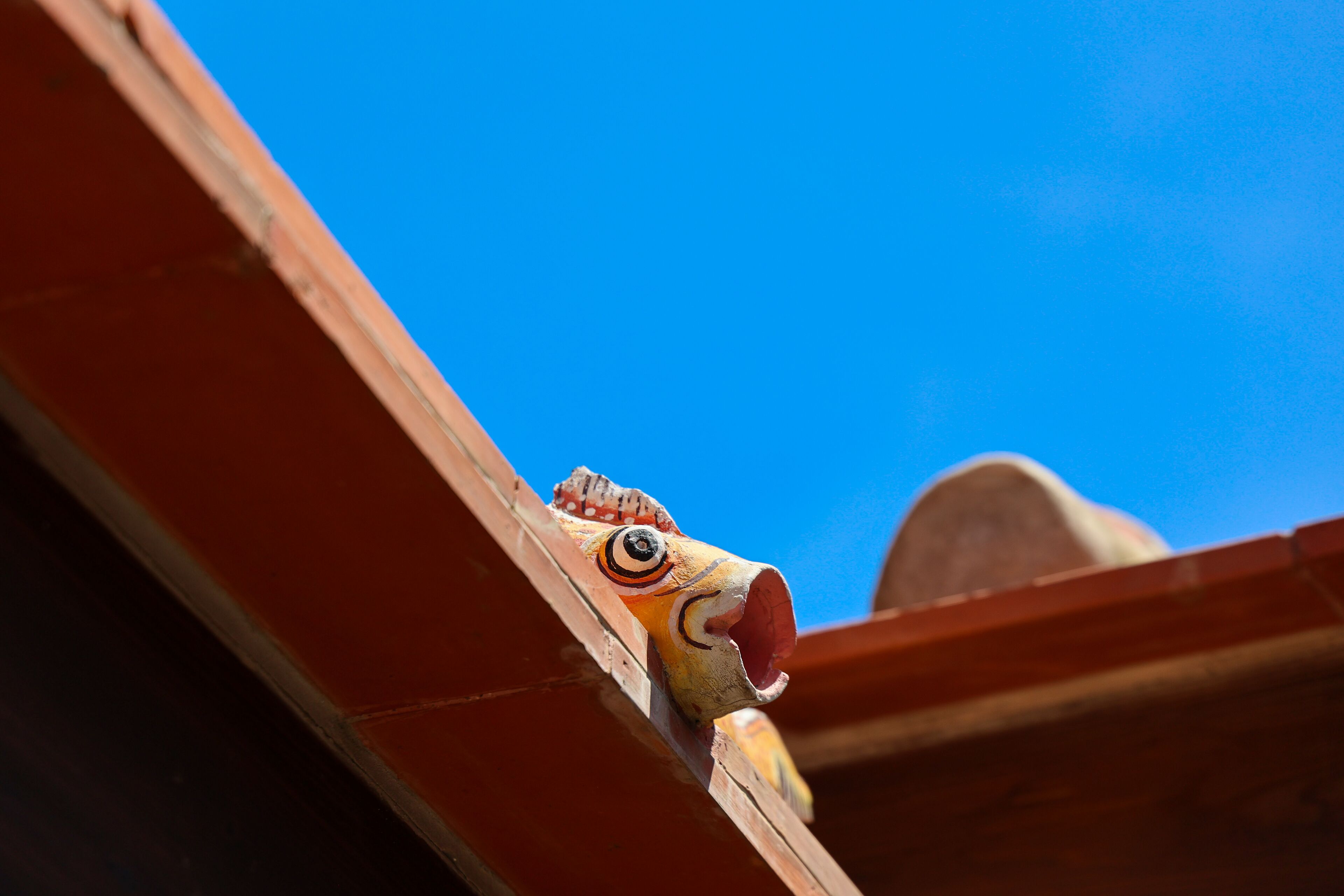 A close-up of a wooden structure with a carved, colorful design.
