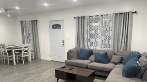 A modern living room with a sofa, coffee table, and dining table. - 3-bedroom farm stay just 13 minutes from Santa Anita Park (Azusa)