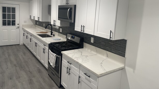 A modern kitchen with white cabinetry, a stainless steel range, a microwave, and a tiled backsplash. - 3-bedroom farm stay just 13 minutes from Santa Anita Park (Azusa)