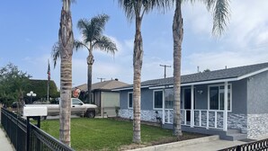 A residential house with a grey and white exterior, a well-maintained lawn, and a black metal fence. - 3-bedroom farm stay just 13 minutes from Santa Anita Park (Azusa)