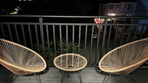A balcony with two wicker chairs and a small table. - Luxury 2 Bedroom Apartment in Heart of Quincy (Quincy)