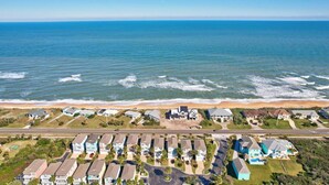 An aerial view of a coastal residential area with houses, a beach, and a clear blue sky. - Sunset Inlet Luxury Oasis | Ocean Views | Private Beach Access | Boat Slip | Beverly Beach | Dogs Ok (Flagler Beach)