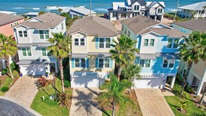A coastal residential area with houses featuring a uniform architectural style, including gabled roofs and a central garage. - Sunset Inlet Luxury Oasis | Ocean Views | Private Beach Access | Boat Slip | Beverly Beach | Dogs Ok (Flagler Beach)