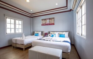 Habitación de hotel con dos camas, un cuadro en la pared y ventanas amplias.